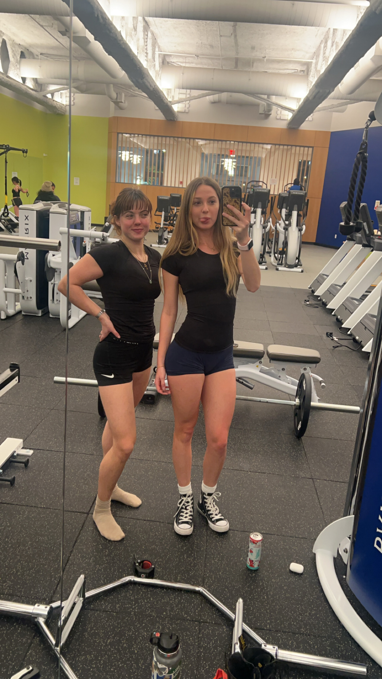 Two young women wearing black in gym